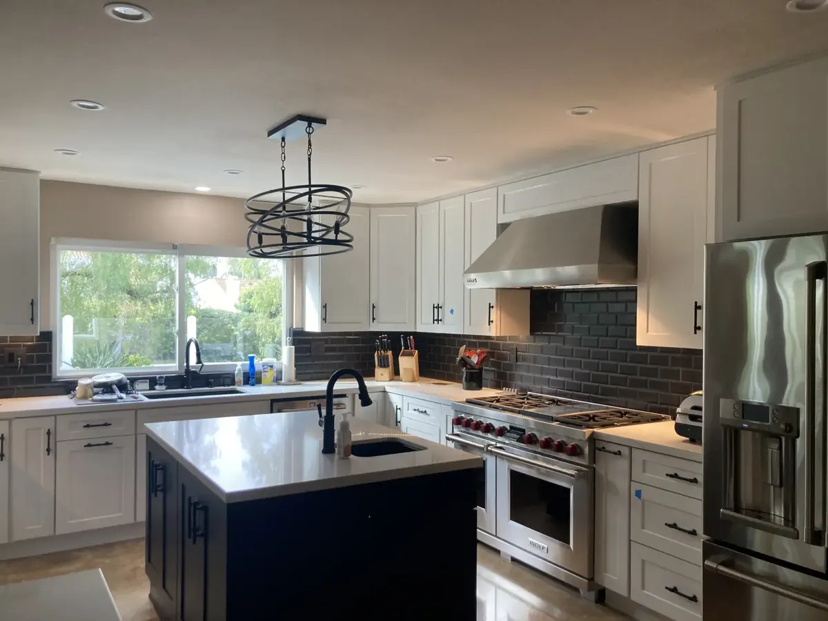 White kitchen with navy island and pro range