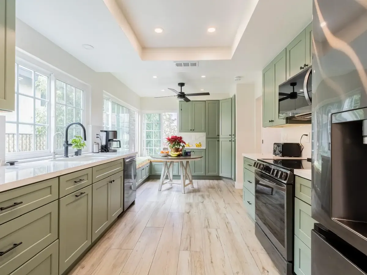 Sage-green shaker kitchen with white quartz counters